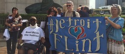 Group of people holding a blue banner that reads "Detroit Flint."