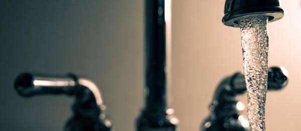 water faucet with water pouring out.